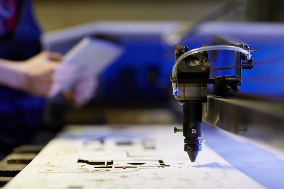 Automatischer Laserschneider schneidet eine Vorlage aus einer Sperrholzplatte