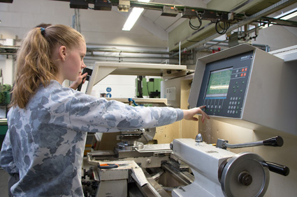 Schülerin zeigt auf Maschine in der Produktion bei Heidrive. Schoolgirl points to machine in production at Heidrive.